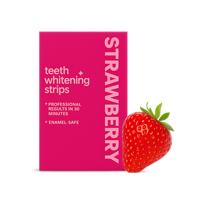 Felle roze verpakking van strawberry teeth whitening strips met witte typografie, gepresenteerd met een verse aardbei met groene kroon tegen een contrasterende witte achtergrond.